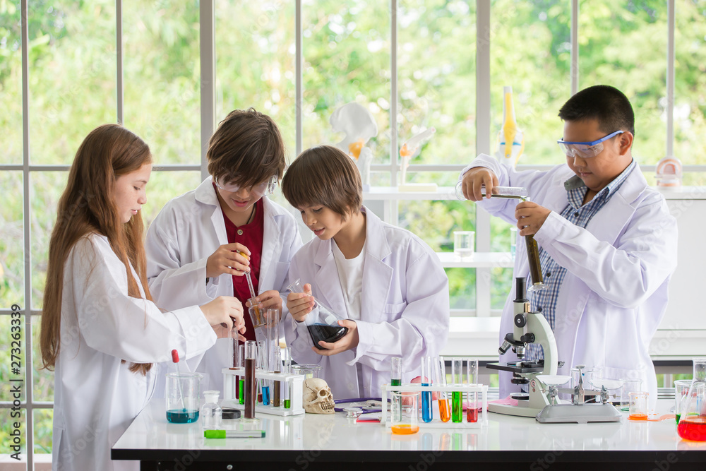 Group of Pupils in white gown doing a chemical experiment in laboratory ...