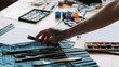 © golubovy - Art workshop. Cropped shot of professional painter picking brush. Watercolor palette in background.