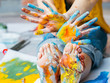 © golubovy - Fine art school. Cropped shot of artist sitting on floor, showing feet and hands dirty with multicolor paint.