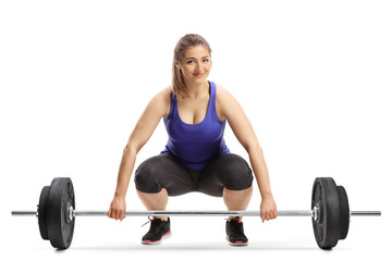 Canvas Print - Cheerful young woman lifting weights and smiling at the camera