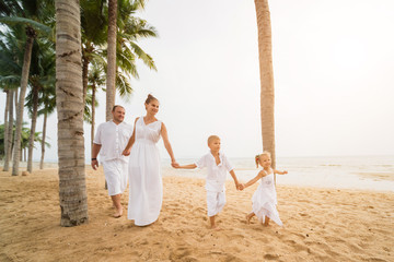 Wall Mural - Happy young family on the sunset at the beach.