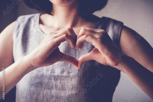Fotomural young woman making her hands in heart shape, heart health insurance, social resp