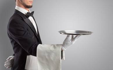 Wall Mural - Waiter serving with white gloves and steel tray in an empty space
