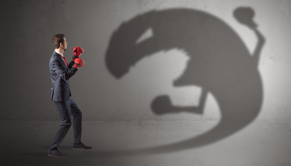 Canvas Print - Businessman with boxing glove fighting with a big monster shadow
