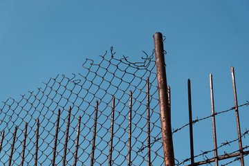 barbed wire fence against blue sky