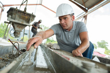 Mature Worker Levelling Cement With Trowel