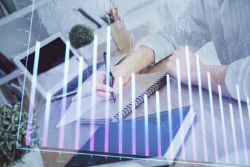 Financial graph displayed on woman's hand taking notes background. Concept of research. Double exposure