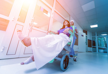 Wall Mural - Nurse moves mobile medical chair with patient at hospital. Medical equipment.
