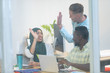 © WavebreakMediaMicro - Business people giving high five while working together at desk in a modern office