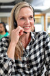 © WavebreakMediaMicro - Female customer service executive looking away while talking on headset in a modern office