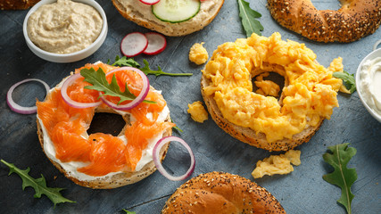 Wall Mural - Healthy Bagels breakfast sandwich with salmon, scrambled eggs, vegetables and cream cheese