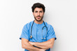 © luismolinero - Surgeon doctor man over isolated white wall keeping arms crossed