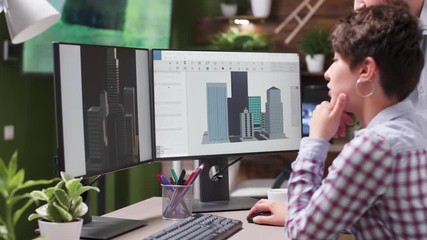 Close up footage of engineer and designer lookign together at building renders and 3D models using a professional software