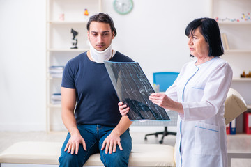 Young male patient visiting aged female doctor 