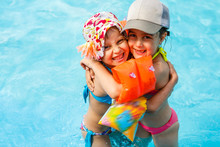 Children Playing In Pool. Two Little Girls Having Fun In The Pool. Summer Holidays And Vacation Concept