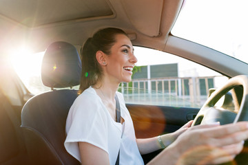 Wall Mural - happy woman driving a car and smiling