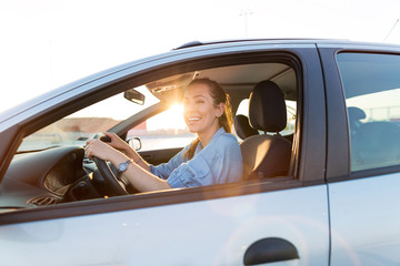 Wall Mural - happy woman driving a car and smiling