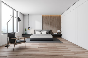 White and wooden bedroom interior with armchair