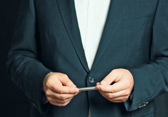 Businessman is holding a presentation or explaining, gesturing with a silver pen in his hand