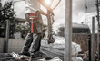 canvas print picture - Bauarbeiter entlädt Bewehrungsstahl von LKW und hängt die Last an die Ketten des Krans