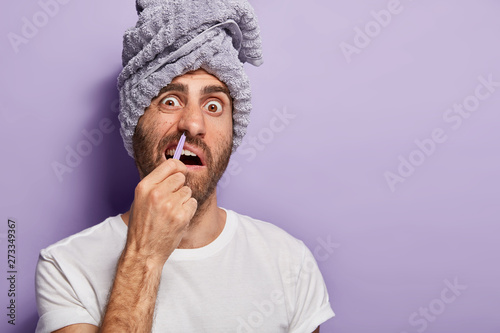 Young Man Removes Nose Hair With Tweezers Smirks And Stares From