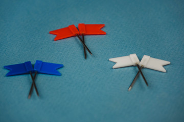 2 flags lying on top of each other in red blue and white on a blue background