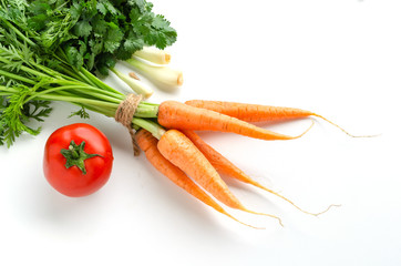 Wall Mural - Fresh carrot with green leaves, tomato, onion and parsley on white background.