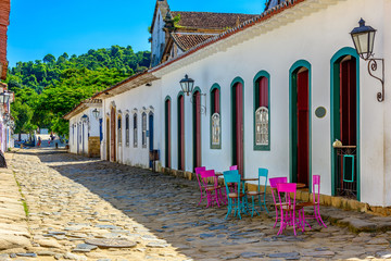 Fototapete - Street with tables of cafe in historical center in Paraty, Rio de Janeiro, Brazil. Paraty is a preserved Portuguese colonial and Brazilian Imperial municipality