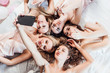 © Тарас Нагирняк - Photo of five, cheerful girls in night robes lying on bed, making selfie, looking  and posing at camera.. Hen party.