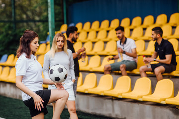 Wall Mural - Two,sportive  female soccer players in uniform  on the field  with boys.