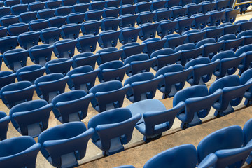 Wall Mural - Rows of blue seats in the stand in the sports arena. One seat open and empty