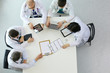 © lenets_tan - Medical team sitting and discussing at table, top view