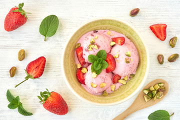 Wall Mural - Strawberry ice cream , frozen yogurt with pistachio and mint leaves. Top view	