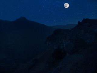 Wall Mural - mountain road through the forest on a full moon night. scenic night landscape of country road at nig