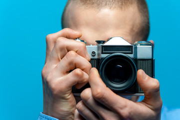 Portrait of young male photographer holding vintage camera