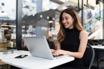 Business woman work process concept. Young woman working university project with generic design laptop. Blurred background, film effect..