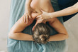 Young blonde woman receiving a back massage in a medical center. Female patient is receiving treatment by professional therapist with beautiful hands. Body positive, harmony, healthy lifestyle, self