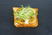 Green Alfalfa Sprouts, Grilled Mushrooms On Toasted Slices Of Wholegrain Bread On Black Stone Slate Background