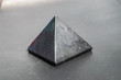 canvas print picture - Shungite stone in the shape of a pyramid close up