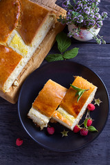 Wall Mural - Cottage cheese pie on black plate. View from above, top studio shot