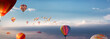 Viele Heißluftballons fliegen  über den Wolken