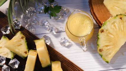 Wall Mural - Pineapple cocktail or juice with ice and pineapples on a dark background, Wooden board with fresh sliced pineapple on table