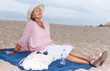 Elderly woman relaxing on beach