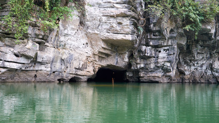 Wall Mural - Entrance to the cave in mountain and Trang An river. Boat tour to grotto. Tam Coc, Ninh Binh, Vietnam.