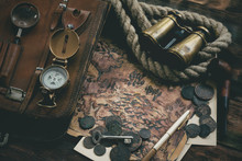 Treasure Map And Adventurer Accessories On A Wooden Table Background. Treasure Hunt Concept Background.
