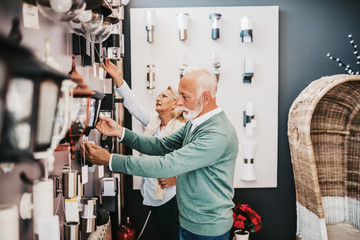 Wall Mural - Senior couple in home lighting store shoosing shandelier for their home