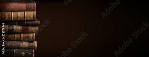 Fotomural literature / reading concept: banner or header image with stack of antique leath