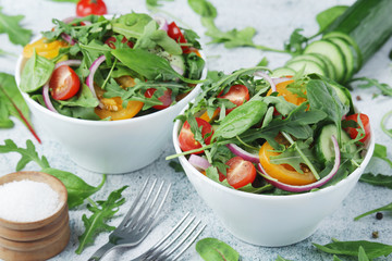 Two bowls full of vegetable salad