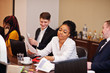 © AS Photo Family - Multiracial business team addressing meeting around boardroom table.