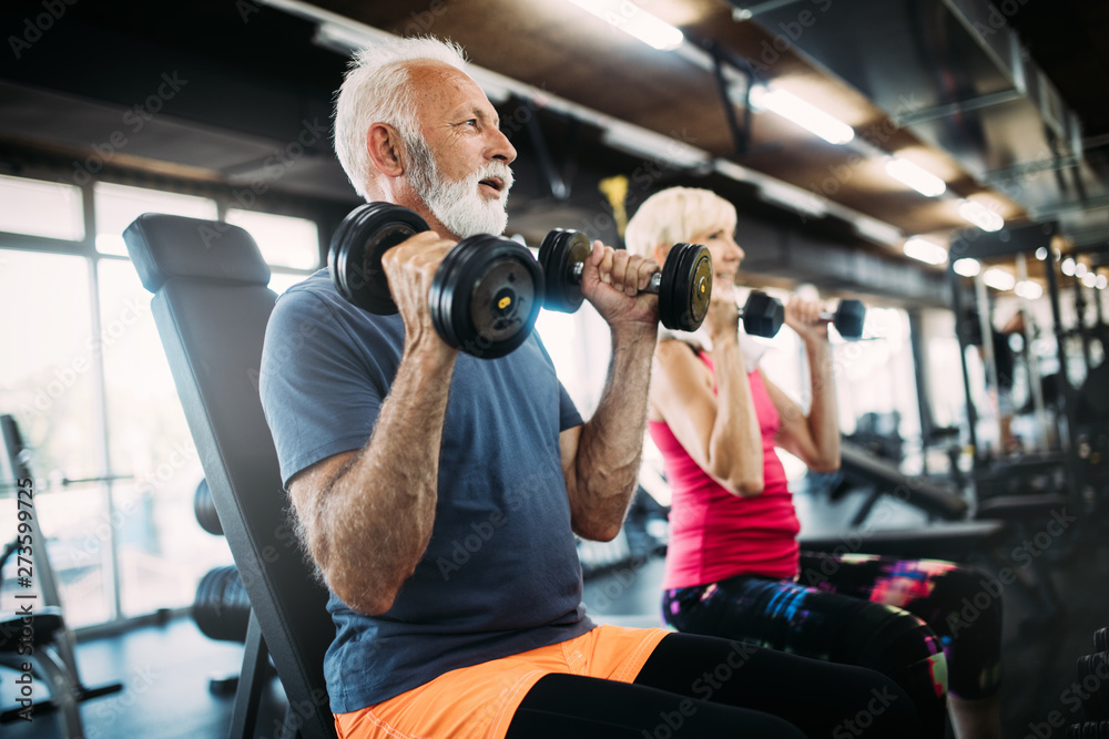 Happy senior people doing exercises in gym to stay fit - obrazy, fototapety, plakaty 